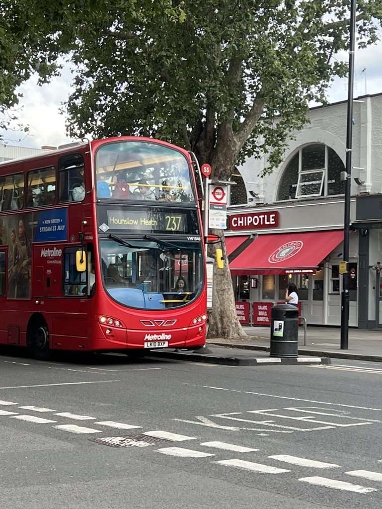 Lively and elegant Chiswick High Road lined with historic brick storefronts, independent cafes, and weekend shoppers.