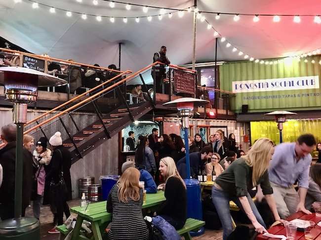 Innovative urban community space at Pop Brixton built from stacked, brightly colored shipping containers housing street food and indie shops.