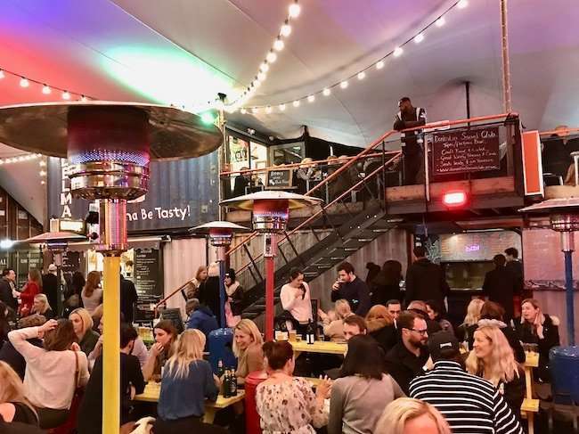Innovative urban community space at Pop Brixton built from stacked, brightly colored shipping containers housing street food and indie shops.